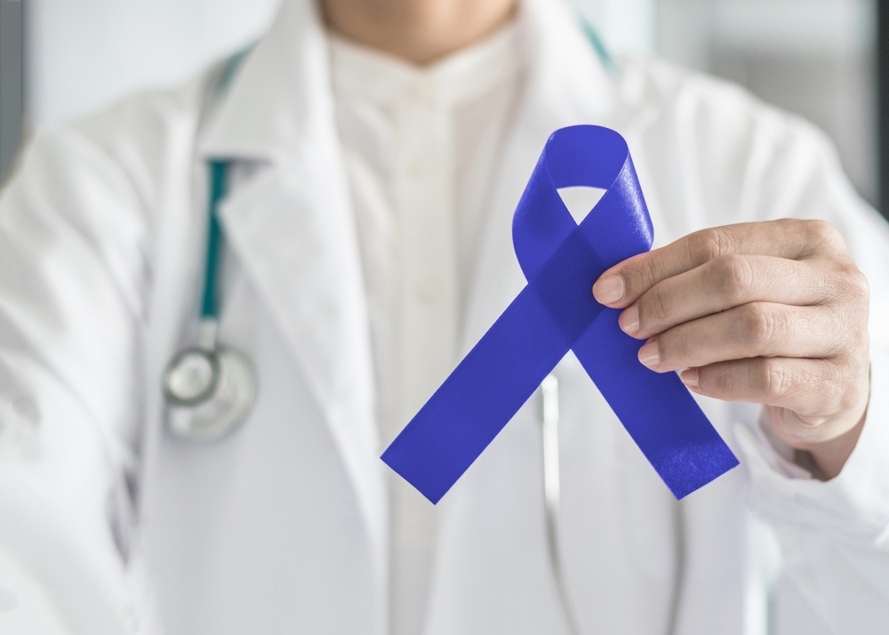 doctor holding a colon cancer awareness ribbin